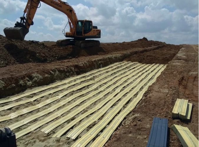Zanja con placas de protección amarillas sobre cables enterrados